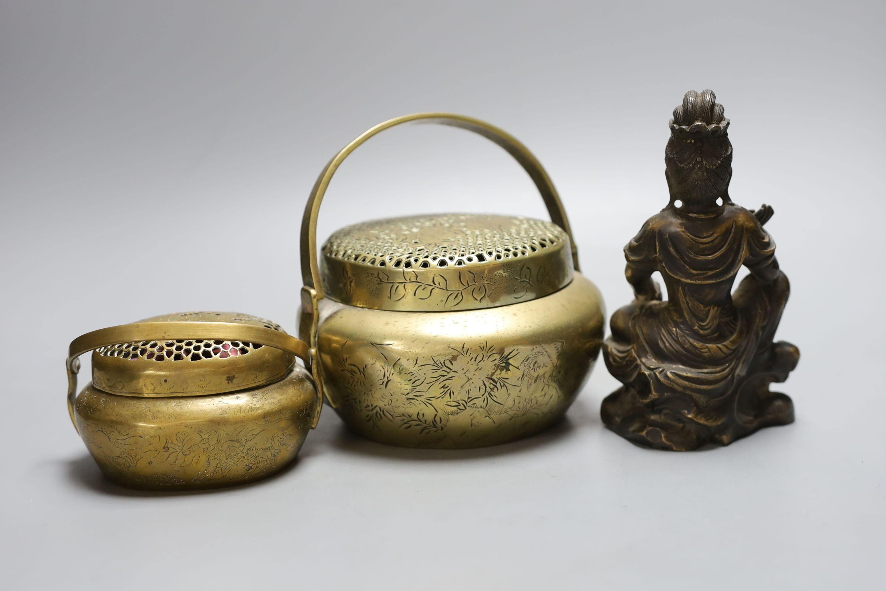 Two Chinese bronze hand warmers, one with Xuande mark, together with a seated Buddha, 16cm tall, (3)